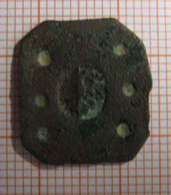 Měděný plech s šesti kroužkovými puncy a půleným znakem, v levém poli polovina orlice. 13x11,6mm, síla plechu 0,8mm, váha 1,32g. Severní Morava