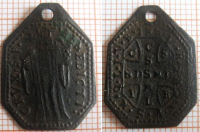 5.Av: stojící postava s  holí ve tvaru kříže v pravé ruce, v levé ruce drží pohár, kolem hlavy svatozář, okraj lemovaný perlovcem, po pravé a levé straně postavy opis: CRUX.S.P. BENEDICTI. Rv: v perlovci okolo vnějšího obvodu opis IHS.V.R.S.N.S.M.V.S.M.Q.L.I.V.B. od opisu LINKOU oddělený a  uprostřed umístněný kříž sv.Benedikta, uvnitř opis, svislé břevno: CSSML, vodorovné břevno NDSMD, mezi rameny: C S P B. 22,6x17,1x0,5mm 1,16g. Měď - ražba.